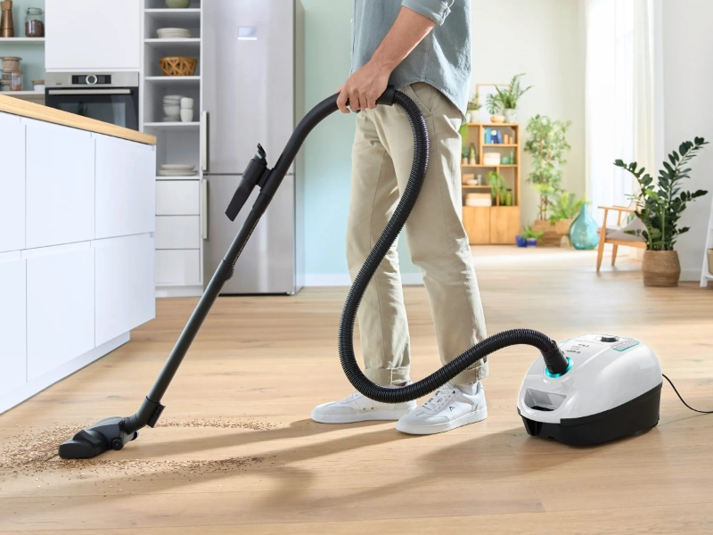 Muž upratuje s vysávačom Bosch BGB38HYG1 Serie 4 ProHygienic