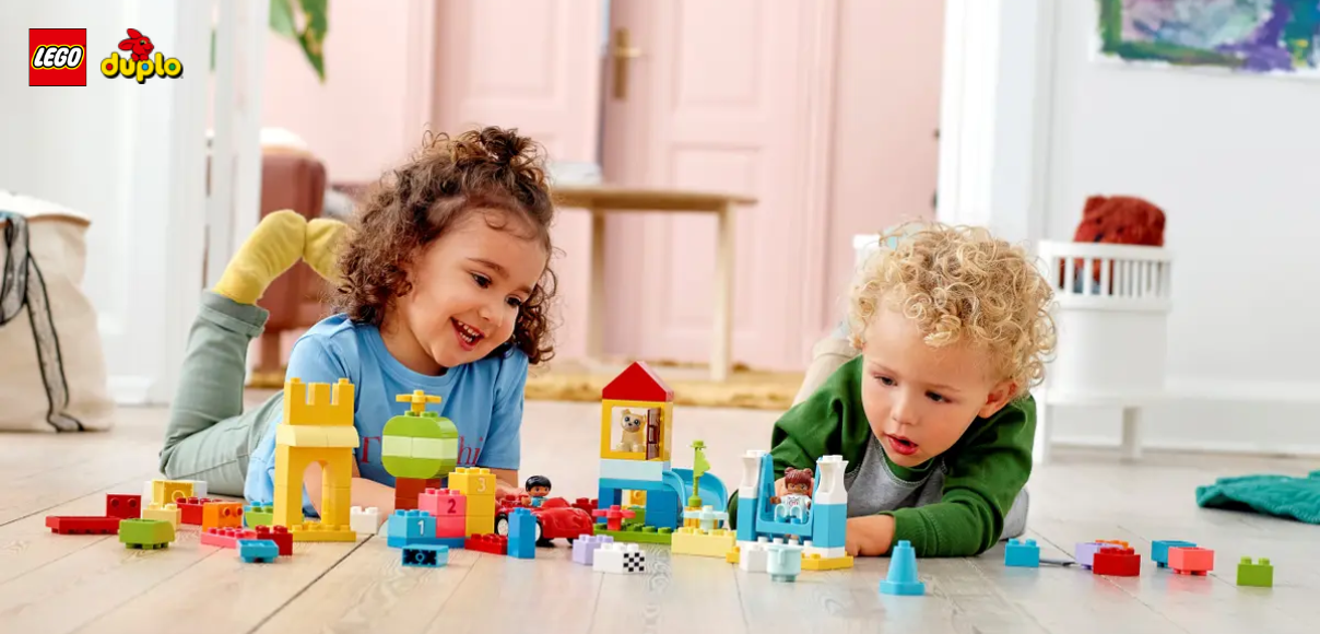 Malé deti sa hrajú so stavebnicou Lego Duplo veľký box s kockami.